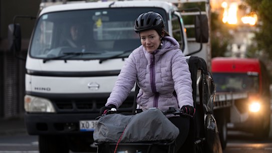 Cyclist on the Bridge Road Cycleway at the junction with Glebe Point Road in Glebe, where cyclists merge with trucks and cars from their protected path.