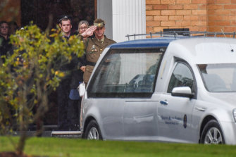 Todd Robinson salutes his long-term partner Glen Humphris following a private funeral service for the police constable at the Victoria Police Academy.