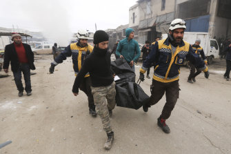 Emergency services carry the body of a person killed in a government air strike in the city of Idlib, province of Idlib, Syria, on Tuesday.