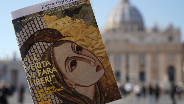 Pope Francis book on "Fake News", is pictured in front of St. Peter's Basilica, in Rome.