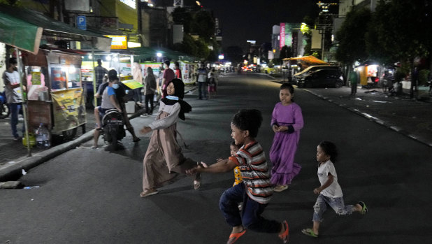Children play in the middle of Sabang Street, a street food center popular among locals and tourists in Jakarta.