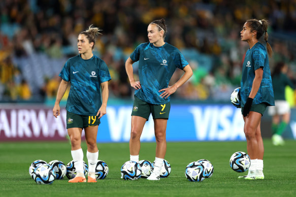 Mary Fowler (right) prepares to partner with Caitlin Foord (centre) in attack during the warm-up before the Matildas’ opening match against Ireland.