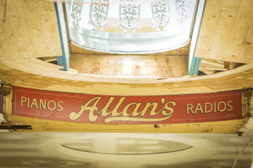 A remnant of Allan's music store sign on the upper wall of the ground floor.