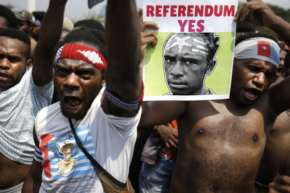 A Papuan activist displays a banner demanding a referendum during a rally near the presidential palace in Jakarta.