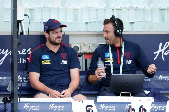 Angus Brayshaw (left) joins Melbourne official Marcus Wagner on the interchange bench.