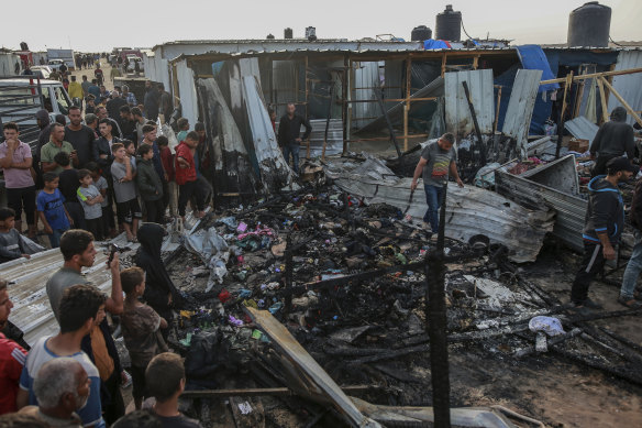 Palestinians survey the destruction after an Israeli strike on a refugee camp in Rafah.