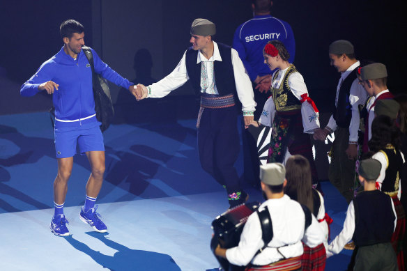 Djokovic dances the kolo with a Serbian dance troupe at a charity match on Rod Laver Arena before the Australian Open.