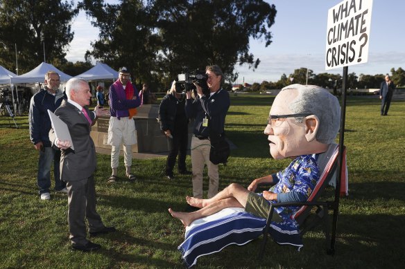 One Nation Senator Malcolm Roberts in debate with a protester wearing a Scott Morrison costume.