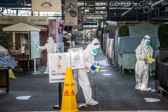 People in hazmat suits give Prahran Market a deep clean on Thursday.