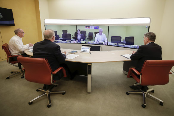 The national cabinet meets on Sunday nightL L-R foreground: Secretary of the Department of Prime Minister and Cabinet, Phil Gaetjens, Prime Minister Scott Morrison and Chief Medical Officer Professor Brendan Murphy, speak with NSW Premier Gladys Berejiklian (on screen).