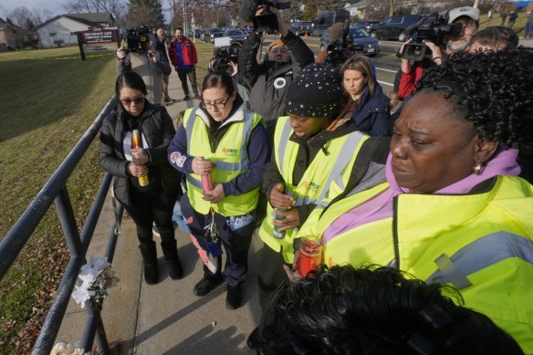 A group says a prayer outside the school.