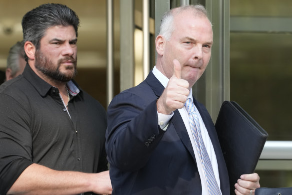 Michael McMahon gives photographers a thumbs up as he leaves Brooklyn Federal court in New York.