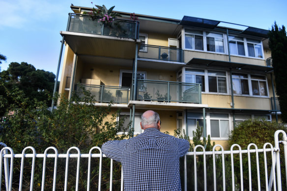 A resident of the old North Melbourne housing estate looks at his home in 2018.