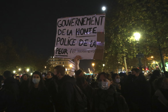 A protester holds a poster reading "Government of shame, Police of fear" during a rally on the Place de La Republique on Tuesday, a day after police ejected migrants by force.
