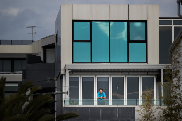 Neill Fitzpatrick on the balcony of his Port Melbourne apartment. Rates on his property have not fallen, despite cladding needing to be rectified on it.