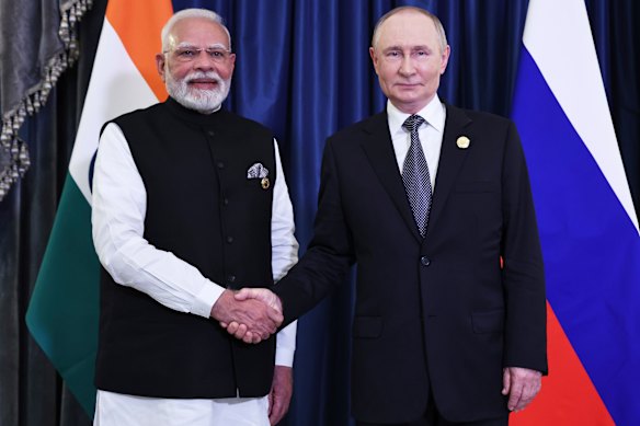 Narendra Modi, à esquerda, e Vladimir Putin apertam as mãos durante a reunião à margem do cume.