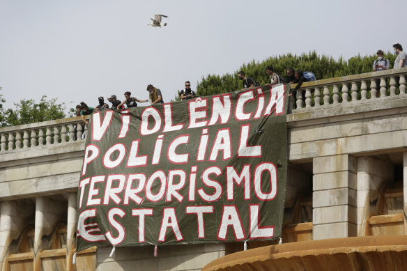 A banner is unfurled in Lisbon, Portugal. It translates to 'Police violence, state terrorism'.  