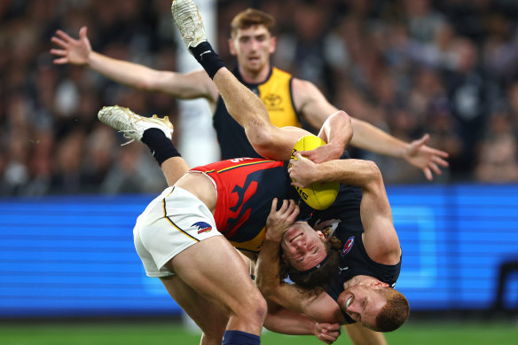 Sam Berry of the Crows is tackled by Matthew Cottrell of the Blues.