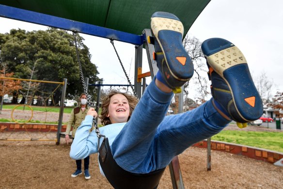 Toby Cummings’ son Louis. 8, enjoys his last swing at a public playground for at least two weeks on Monday.