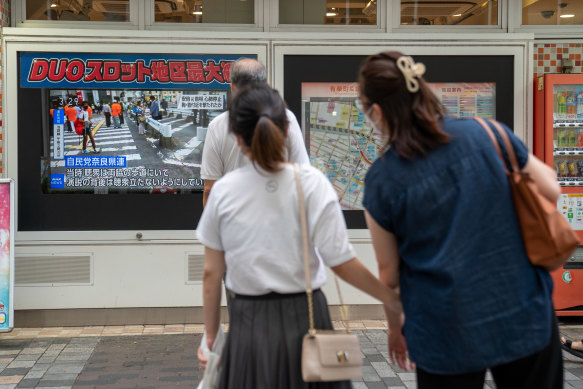 Tokyo’s residents stop to watch news of Shinzo Abe’s attempted assassination. 