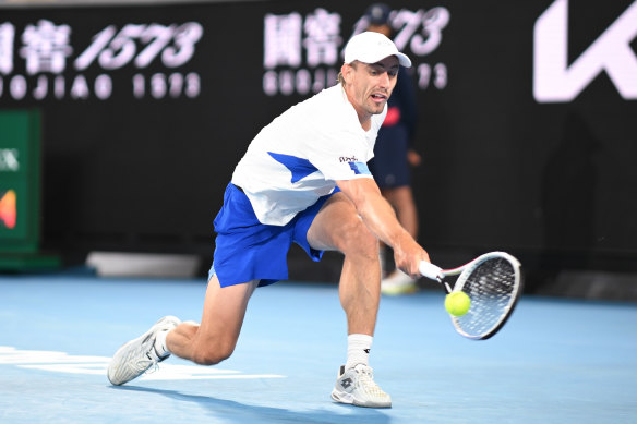 John Millman returns the ball to Daniil Medvedev.