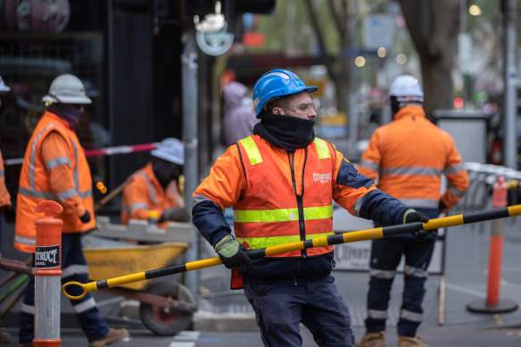 Construction workers erect barriers as they return to work in Melbourne’s CBD on Tuesday morning.
