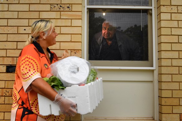 Tharawal Aboriginal Corporation case worker Kim Bell delivers groceries to 73-year-old Ivan Wellington.