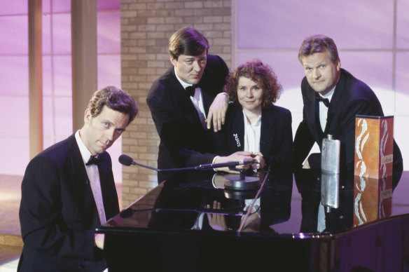With, from left,  Hugh Laurie, Stephen Fry and Clive Mantle standing around a piano in A Bit of Fry and Laurie, 1994.