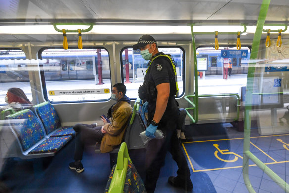 Police check to see if passengers are wearing a mask on a train at Southern Cross station last week.