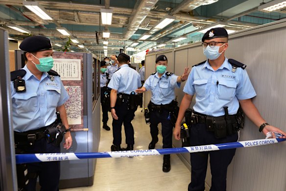 Police officers set up cordon line inside the Apple Daily newspaper headquarters. 