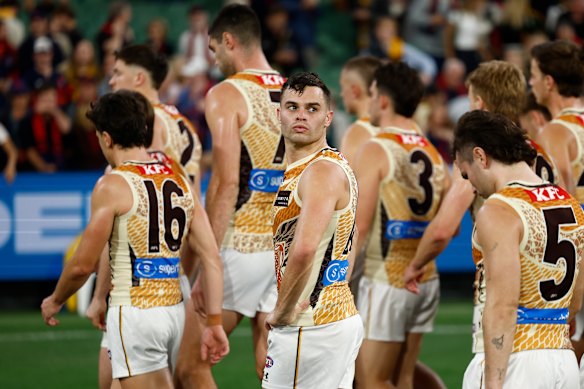 The Hawks walk off the MCG after their loss to the red-hot Demons.