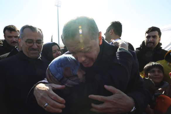 Türkiye Cumhurbaşkanı Recep Tayyip Erdoğan ve hayatta kalan bir kişi, Türkiye'nin güneyindeki Kahramanmaraş'ta yıkılan şehir merkezini ziyaret ederken birbirlerine sarılıyor. 