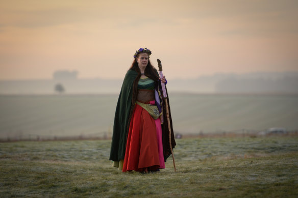A woman watches the sunrise at Stonehenge in Amesbury, an iconic site for pre-Christian Britain. 
