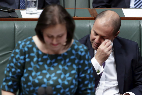 Treasurer Josh Frydenberg dabs his eyes while listening to Kelly O'Dwyer.