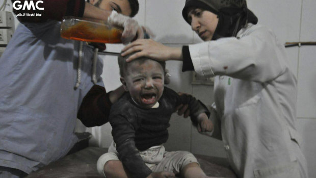 Paramedics treat a Syrian child who was wounded during airstrikes and shelling by Syrian government forces in Ghouta.