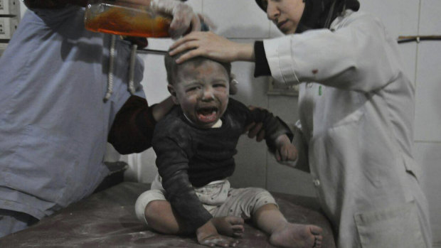 Paramedics treat a Syrian child who was wounded during airstrikes and shelling by Syrian government forces in Ghouta.