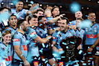 Isaah Yeo prepares to raise the shield surrounded by NSW teammates.