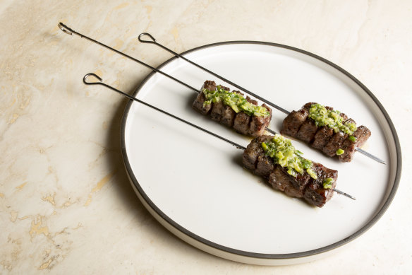 Wattleseed and coffee-marinated wagyu skewers with green salsa and chives.