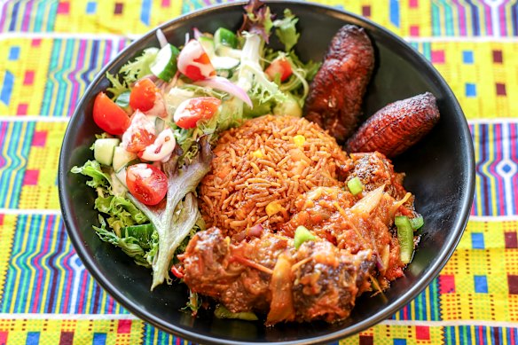 Arroz jollof liberiano com carne, banana frita e salada temperada.