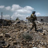 A soldier with the United Nations Interim Force inspects a house destroyed by an Israeli attack in Yarine, southern Lebanon.