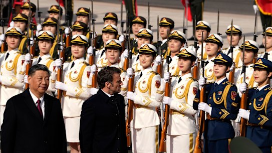 French President Emmanuel Macron, centre, inspects an honour guard with Chinese President Xi Jinping, left, outside the Great Hall of the People in Beijing, on Thursday.