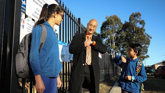 Merrylands East Primary School principal John Goh greets students Maitreyi and brother Yajat Patel.