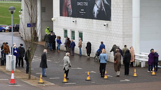 Members of the public queue to receive the Oxford-AstraZeneca coronavirus vaccine at a mass vaccination centre at a racecourse in England this month.