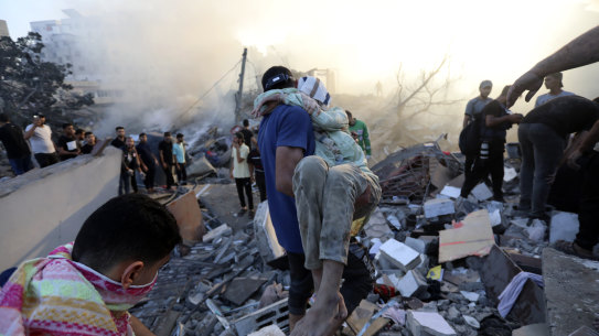 A Palestinian man evacuates a wounded girl out of the destruction following Israeli airstrikes on Gaza City.