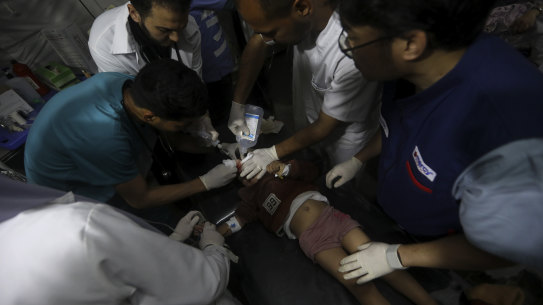 Palestinian medics treat a wounded child in Rafah, Gaza Strip on Saturday.