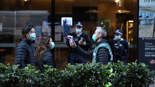 People queuing for the new mass vaccination hub in Sydney’s CBD have their temperature checked on Monday morning. 