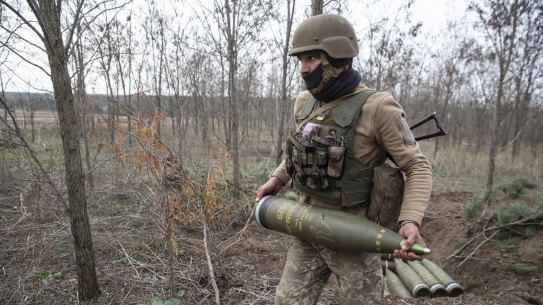 A Ukrainian soldier prepares shells to fire at Russian armoured vehicles outside Kherson.