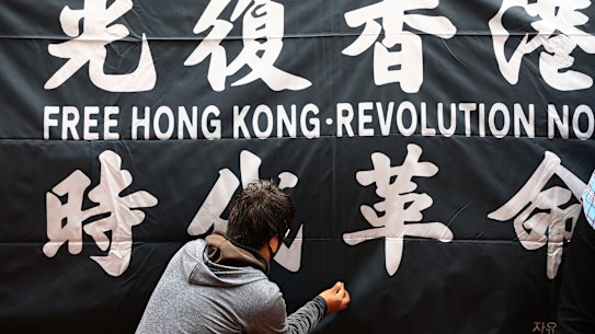 A man hangs a banner during a rally to support Hong Kong pro-democracy protests in front of Chinese Embassy on July 07, 2020 in Seoul, South Korea. Protesters criticize the Chinese government's new national security law for Hong Kong. (Photo by Chung Sung-Jun/Getty Images)
