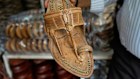A shopkeeper shows Kolhapuri sandals to a customer at shop in Mumbai. 