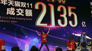 An Alibaba staff member dances in front of a big screen trumpeting sales figures at the gala event in Shanghai. 